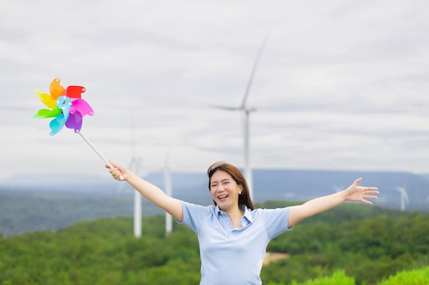 Concetto di donna felice progressista che si gode il suo tempo al parco eolico