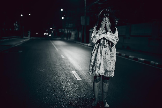 Concetto di donna horrorFantasma sulla strada della cittàUno spirito vendicativo sulla strada della cittàHalloween festivalMake up ghost face