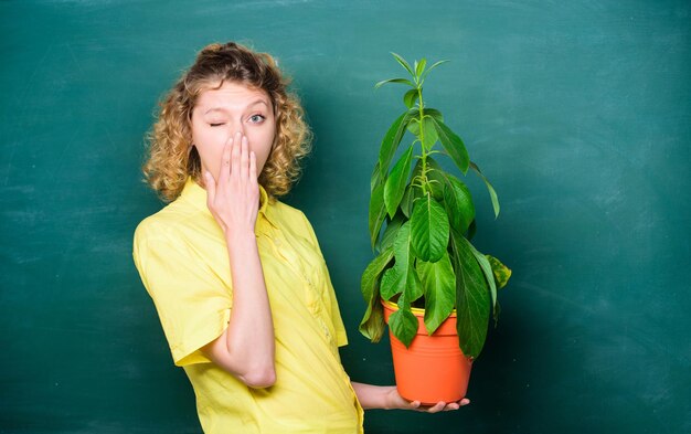 Concetto di ecologia. insegnante donna con gli occhiali alla lezione di biologia. studentessa con pianta alla lavagna. educazione ambientale. studio della natura scolastica. albero della conoscenza. ecologia dell'apprendimento scolastico.