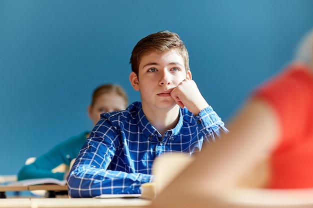 concetto di educazione, apprendimento e persone - gruppo di studenti con quaderni a lezione di scuola