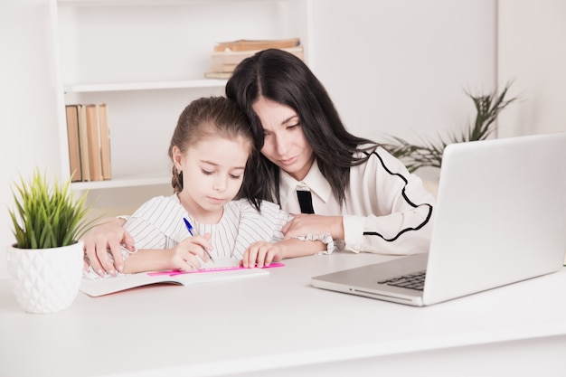 Concetto di educazione domestica. Tutor e ragazza che fanno i compiti insieme.