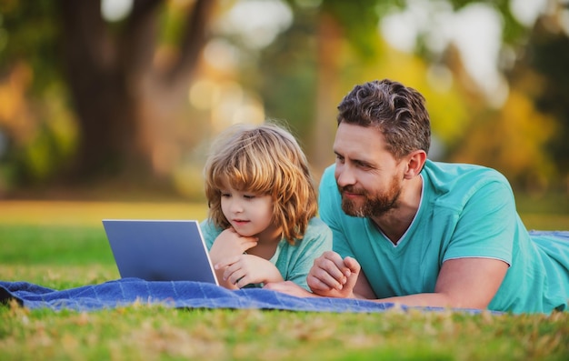 Concetto di educazione familiare Padre che insegna al figlio come utilizzare il computer portatile del computer portatile