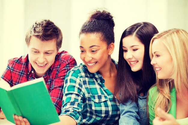 concetto di educazione - gruppo di studenti che leggono un libro a scuola