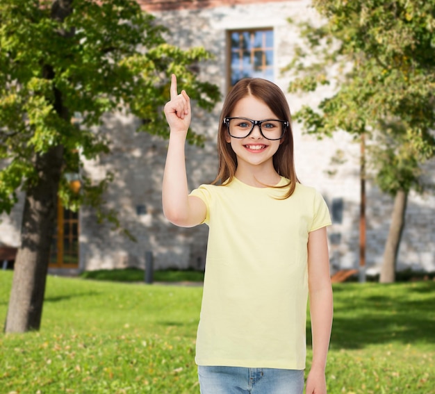 concetto di educazione, scuola e visione - bambina carina sorridente con occhiali neri