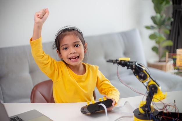 Concetto di educazione STEM Gli studenti asiatici imparano a casa codificando braccia robotiche in matematica STEM ingegneria scienza tecnologia codice computer in robotica per concetti per bambini