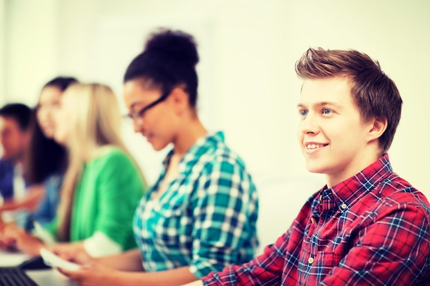 concetto di educazione - studente con computer che studia a scuola