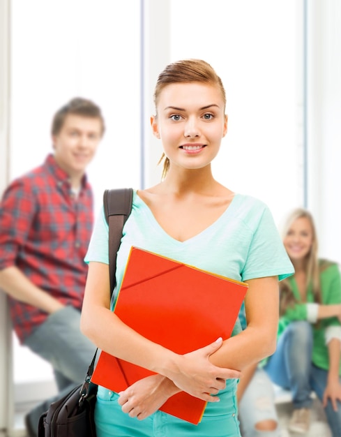 concetto di educazione - studentessa sorridente con cartelle e borsa di scuola