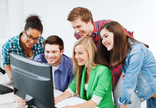 concetto di educazione - studenti con computer che studiano a scuola