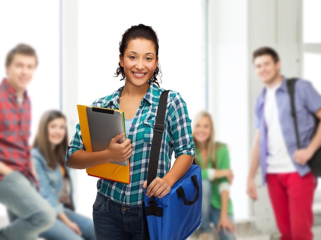 concetto di educazione, tecnologia e persone - studentessa afroamericana sorridente con cartelle, borsa e tablet pc