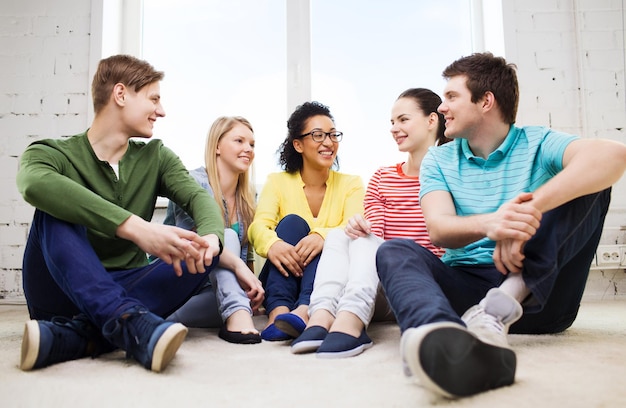 concetto di educazione, tempo libero e felicità - cinque adolescenti sorridenti che si divertono a casa