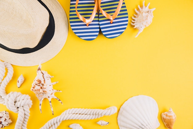 Concetto di estate Accessori da viaggio: un cappello di paglia, una macchina fotografica, una corda, conchiglie e pantofole.