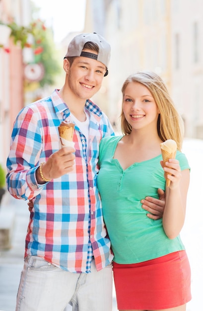 concetto di estate, vacanza, amore e amicizia - coppia sorridente con gelato in città