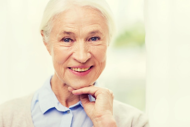 concetto di età e persone - volto di donna senior sorridente felice a casa