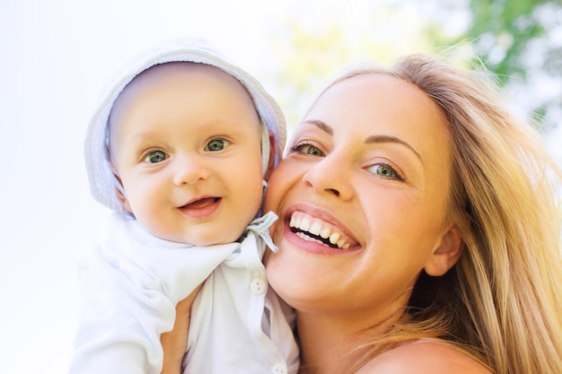 concetto di famiglia, bambino e genitorialità - madre felice con bambino piccolo all'aperto