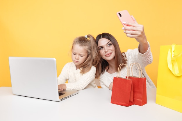 Concetto di famiglia di blogger. Bella madre e figlia carina che fanno foto insieme sul telefono.
