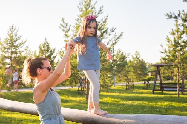 Concetto di famiglia e bambino madre e figlia che camminano e giocano nel parco e si divertono