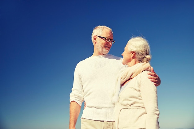 concetto di famiglia, età e persone - coppia di anziani felici che parlano all'aperto