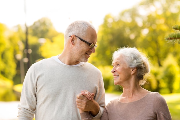 concetto di famiglia, età, turismo, viaggi e persone - coppia senior nel parco cittadino