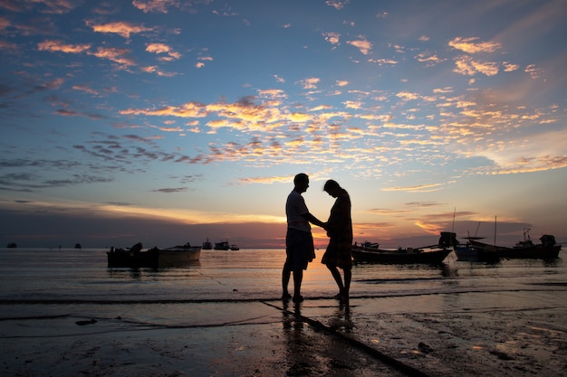 Concetto di famiglia felice, coppia sullo sfondo tramonto spiaggia