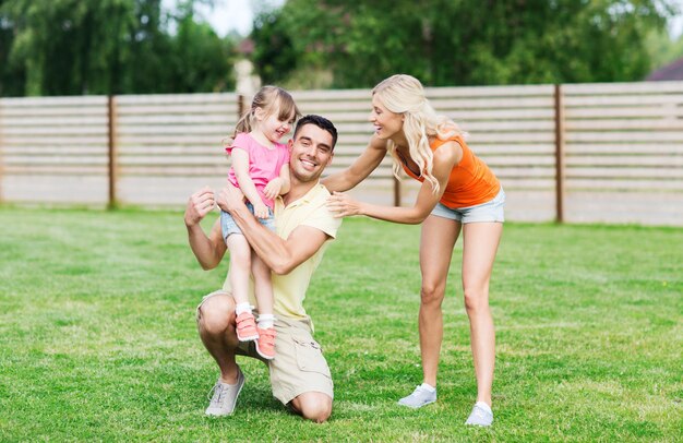 concetto di famiglia, felicità, adozione e persone - famiglia felice che si abbraccia all'aperto