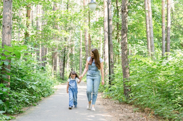 Concetto di famiglia, genitorialità e natura - Madre con figlia che si diverte nel parco verde.