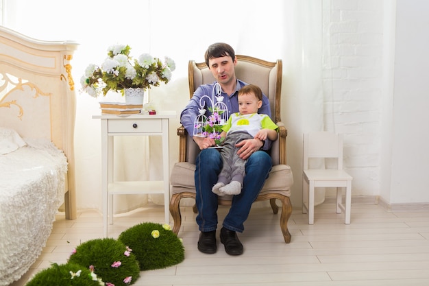 Concetto di famiglia, infanzia, paternità, attività e persone - padre felice e figlio piccolo che giocano a casa.