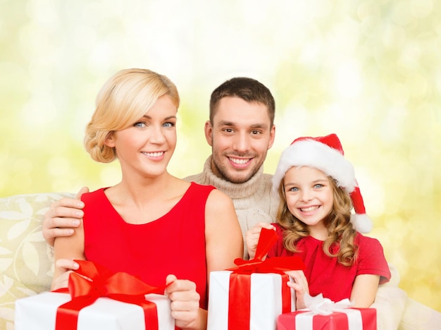 concetto di famiglia, natale, natale, felicità e persone - famiglia sorridente in cappelli di Babbo Natale con molte scatole regalo