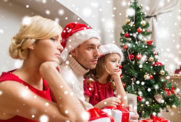 concetto di famiglia, natale, natale, inverno e persone - famiglia infelice a casa con molte scatole regalo