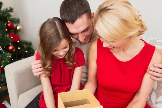 concetto di famiglia, natale, vacanze, felicità e persone - confezione regalo di apertura famiglia felice