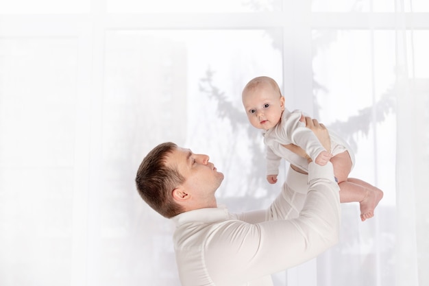 Concetto di famiglia, paternità e persone - padre felice che tiene piccola figlia a casa, festa del papà