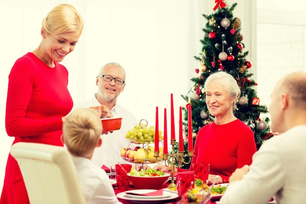 concetto di famiglia, vacanze, generazione, natale e persone - famiglia sorridente che cena a casa