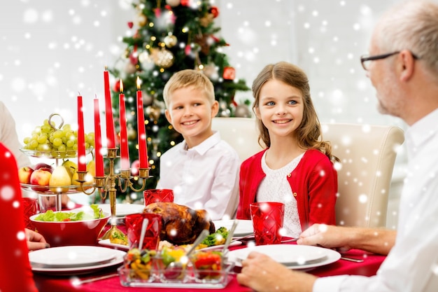 concetto di famiglia, vacanze, generazione, natale e persone - famiglia sorridente che cena a casa