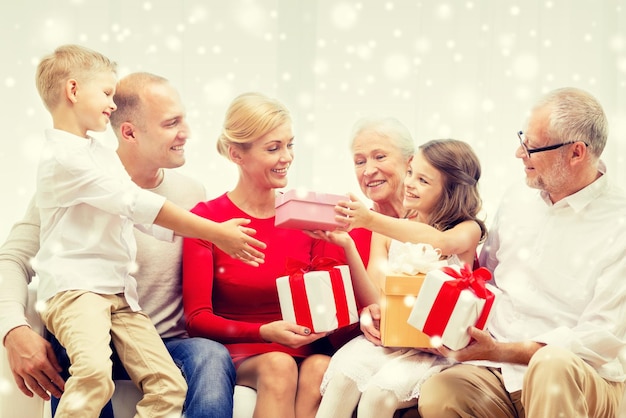 concetto di famiglia, vacanze, generazione, natale e persone - famiglia sorridente che si regala regali a casa