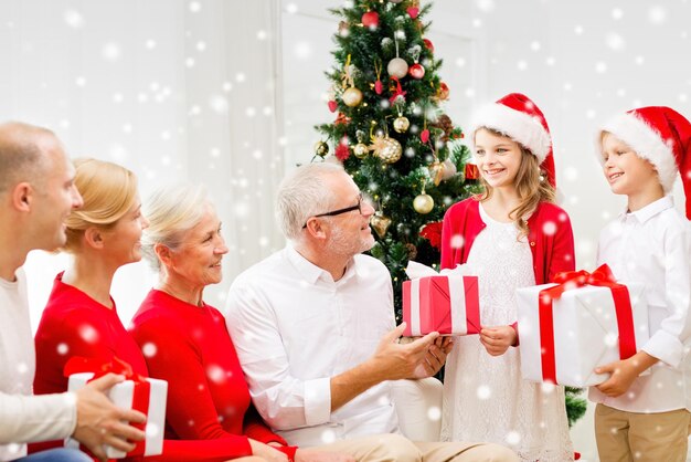 concetto di famiglia, vacanze, generazione, natale e persone - famiglia sorridente con scatole regalo a casa