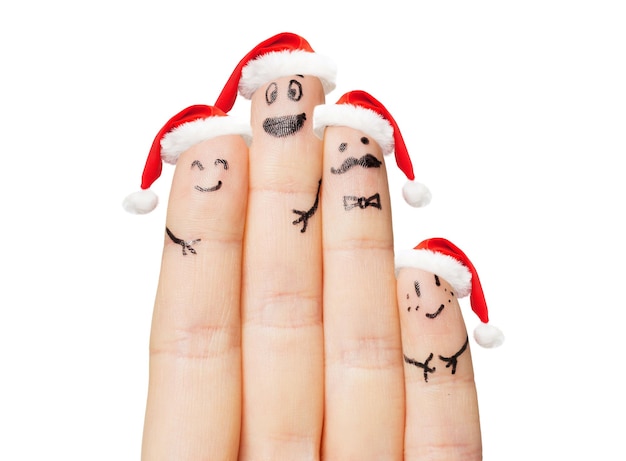 concetto di famiglia, vacanze, natale e parti del corpo - primo piano della mano con quattro dita in cappelli di Babbo Natale con faccine sorridenti