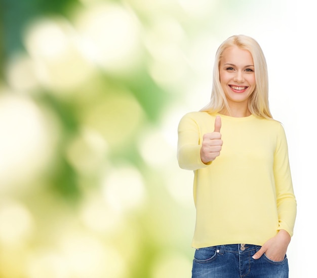 concetto di felicità, gesto e persone - giovane donna sorridente in abiti casual che mostra i pollici in su