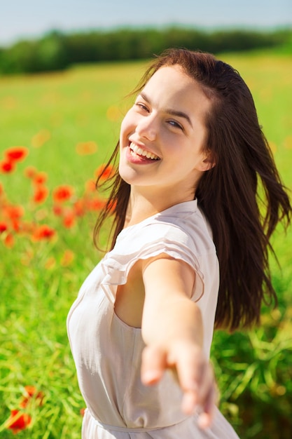 concetto di felicità, natura, estate, vacanze e persone - giovane donna ridente sul campo di papaveri