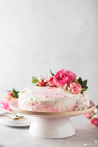 Concetto di festa di compleanno con torta bianca rosa decorata con rose rosa, immagine di messa a fuoco selettiva