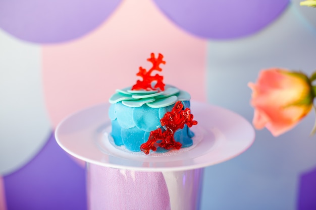 Concetto di festa di compleanno. Tavolo per bambini con cupcakes con piano blu e rosso e oggetti decorati nei colori blu e viola. Stagione estiva deliziosa per la festa.