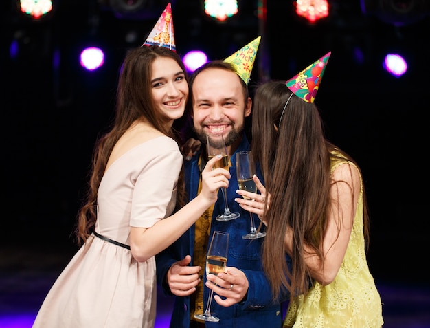 Concetto di festa, vacanze, celebrazione, vita notturna e persone - amici sorridenti con bicchieri di champagne nel club