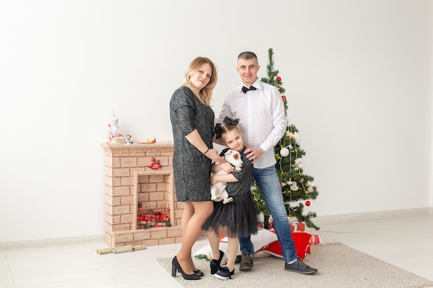 Concetto di feste - padre e figlio felici della madre della famiglia all'albero di Natale a casa.