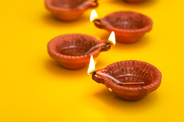 Concetto di festival indiano diwali Lampade a olio tradizionali su sfondo giallo
