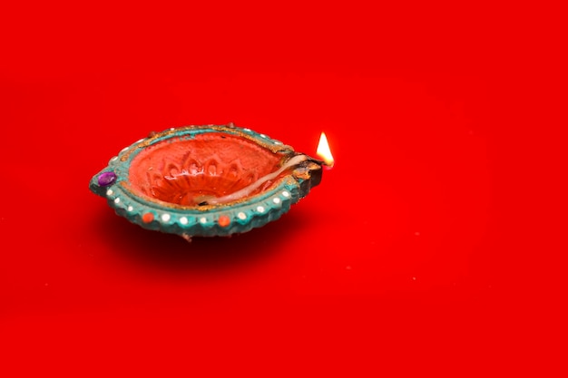 Concetto di festival indiano diwali Lampade a olio tradizionali su sfondo rosso