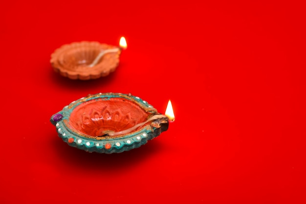 Concetto di festival indiano diwali Lampade a olio tradizionali su sfondo rosso