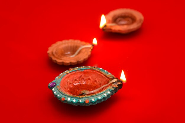 Concetto di festival indiano diwali Lampade a olio tradizionali su sfondo rosso