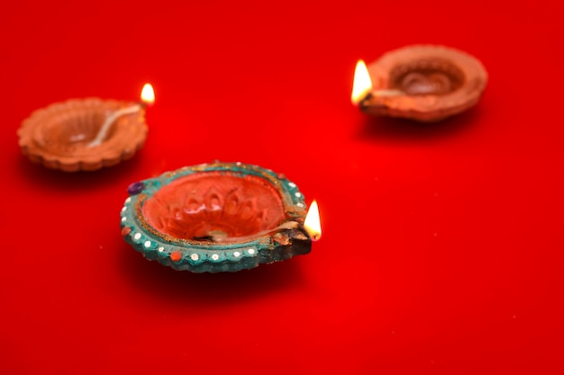 Concetto di festival indiano diwali Lampade a olio tradizionali su sfondo rosso