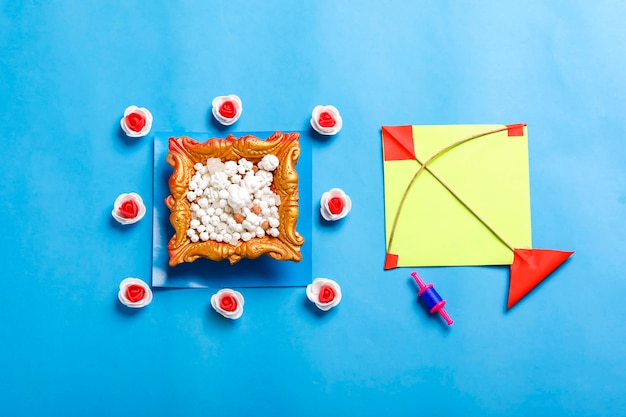 Concetto di festival indiano makar sankranti, aquilone colorato, corda e palla di semi di sesamo dolce.