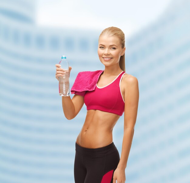 concetto di fitness, calore e dieta - donna sportiva con bottiglia d'acqua e asciugamano