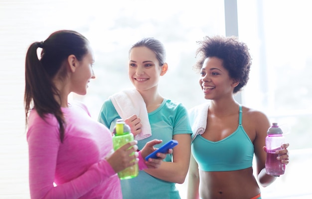 concetto di fitness, sport, allenamento, palestra e stile di vita - gruppo di donne felici con bottiglie d'acqua in palestra