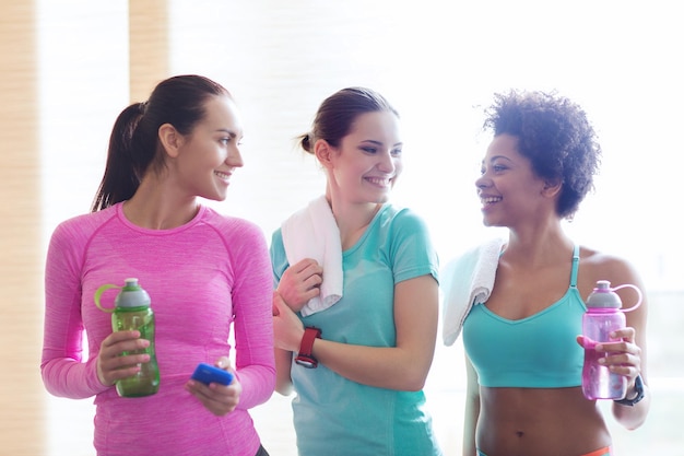 concetto di fitness, sport, allenamento, palestra e stile di vita - gruppo di donne felici con bottiglie d'acqua in palestra